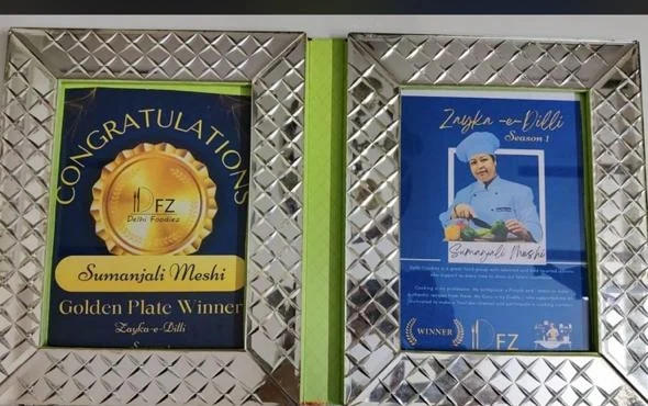 Two framed Zayka-e-Dilli Golden Plate winner certificates for Sumanjli Meshi